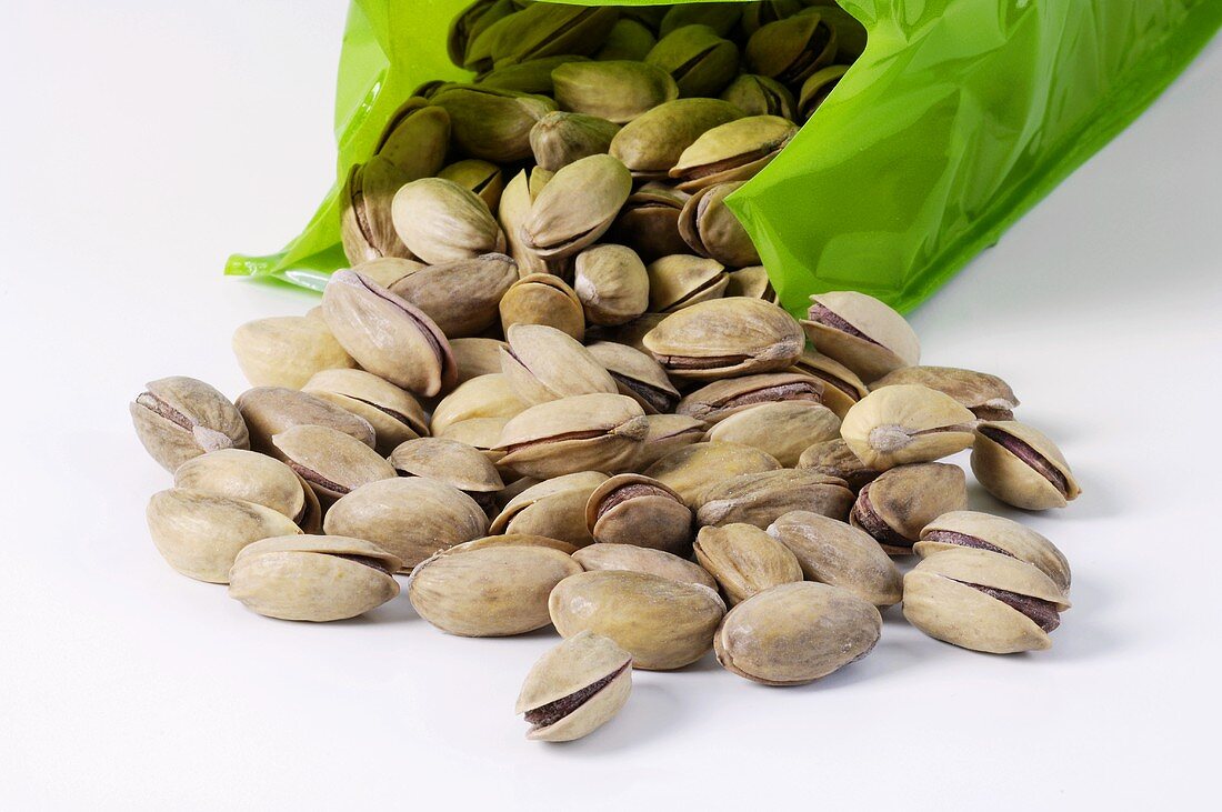 Pistachios in their shells in front of packaging