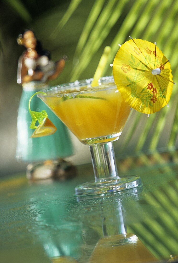 Fruchtiger Drink mit Rum im Glas mit Cocktailschirmchen