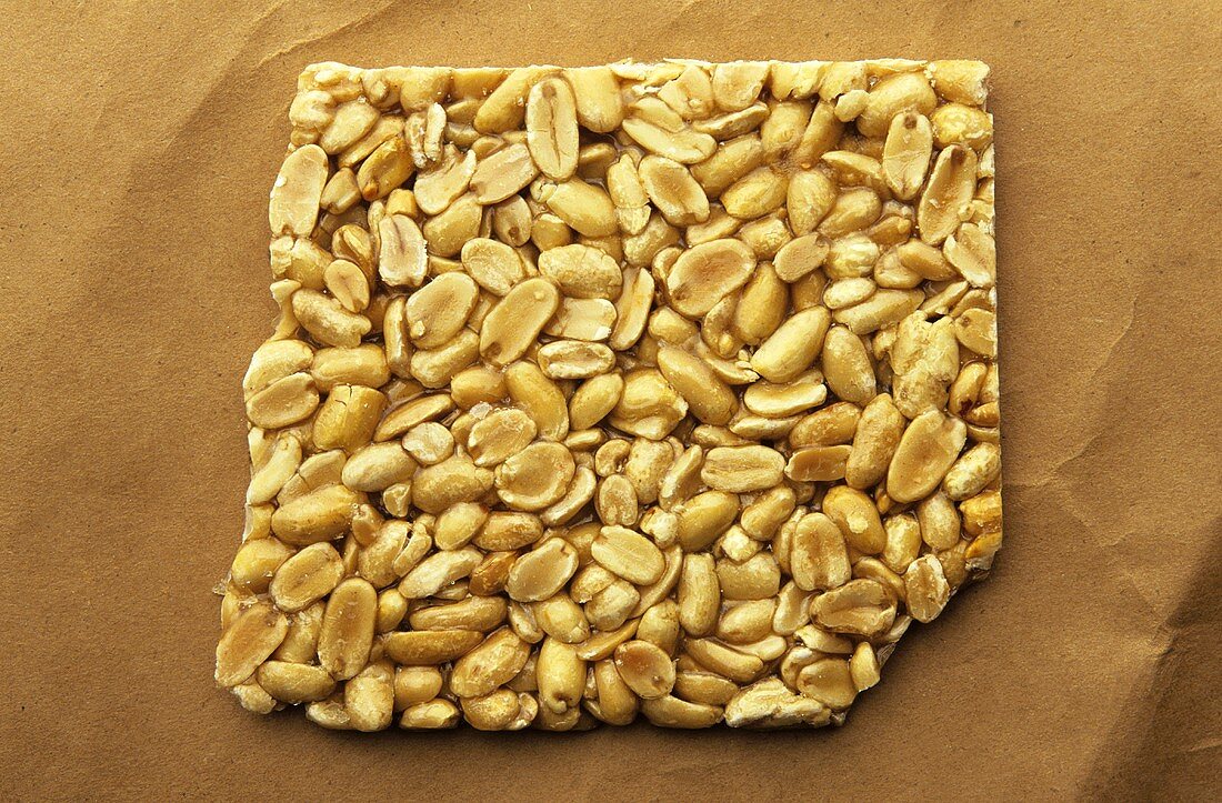 Erdnuss-Brittle auf braunem Papier