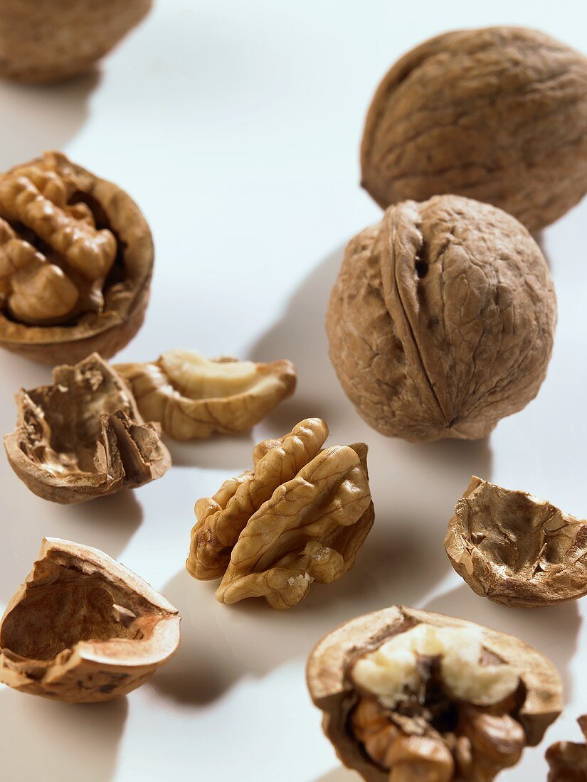 Whole and opened walnuts on white background