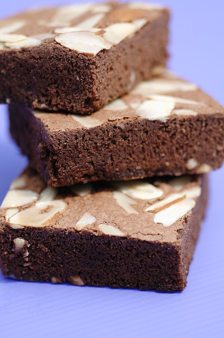 Three brownies with almonds in a pile