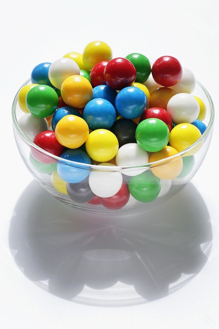 Lots of coloured chewing gum balls in a glass bowl