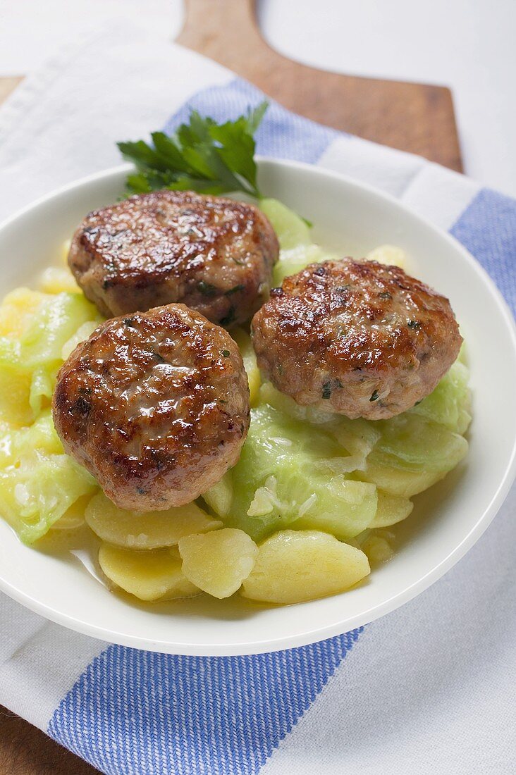 Burgers on potato and cucumber salad