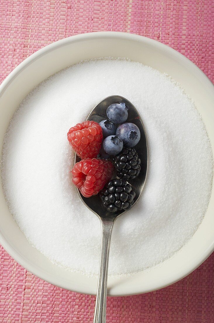 Ein Löffel mit gemischten Beeren im Zucker