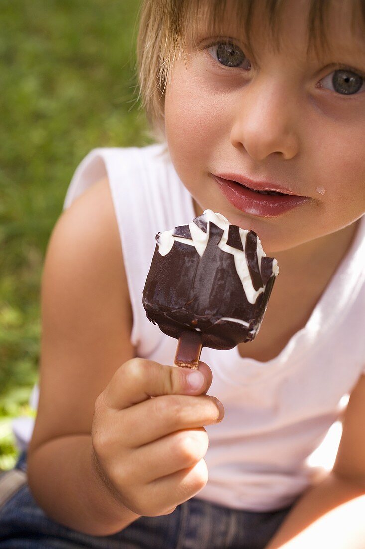 Small child holding an ice cream on a stick