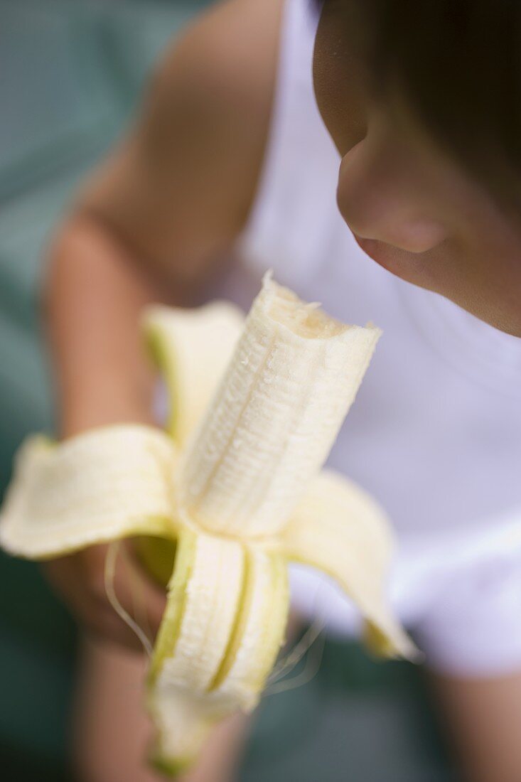 Small child eating a banana