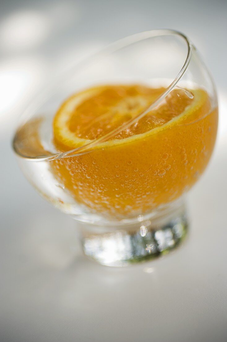 Ein Glas Mineralwasser mit einer halben Orange