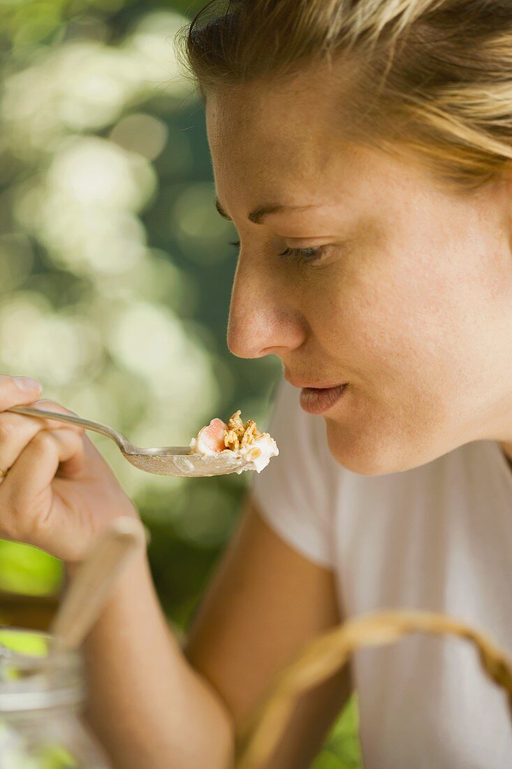 Junge Frau isst Müsli