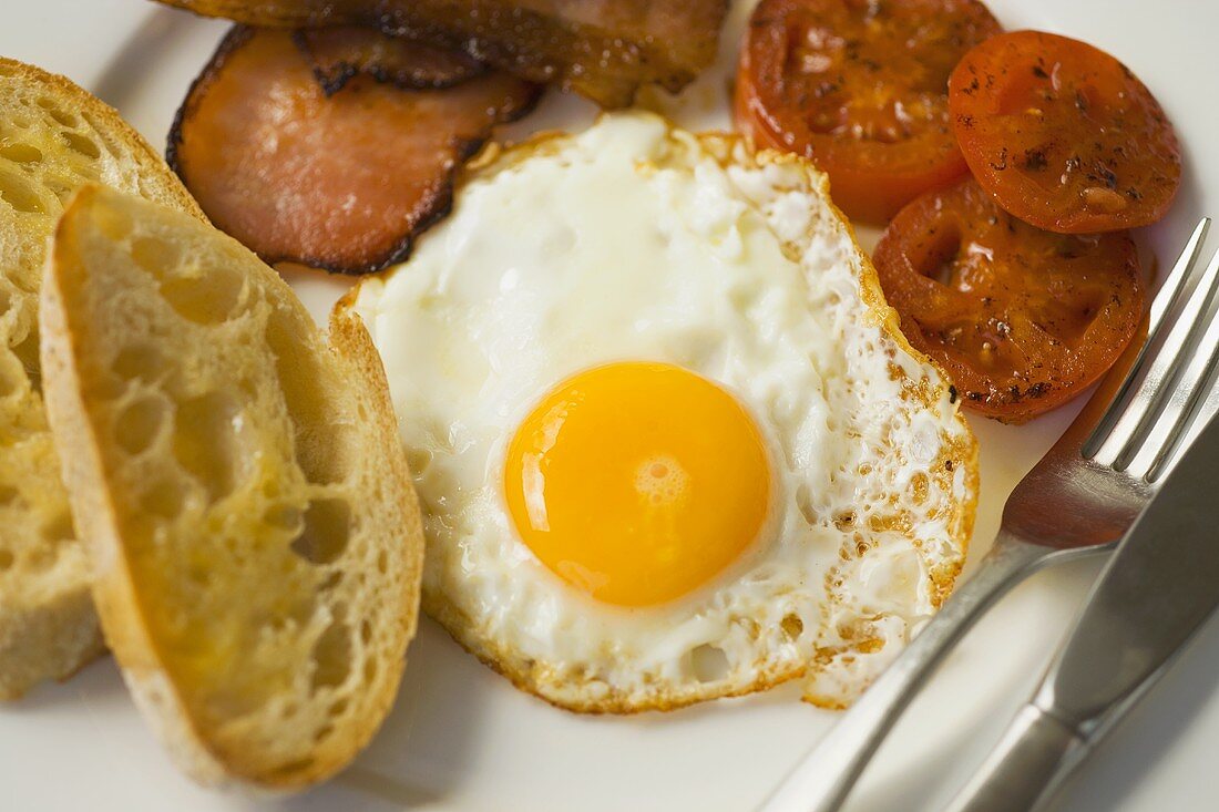 Englisches Frühstück mit Spiegelei, Speck und Tomaten