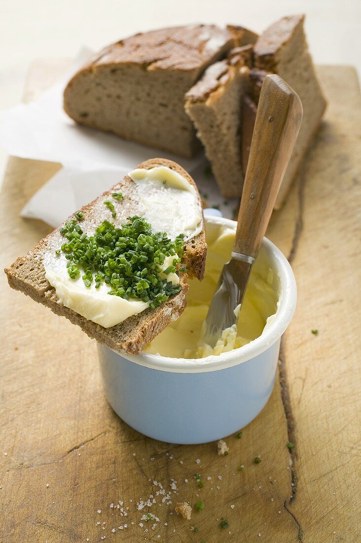 Ein Schnittlauchbrot auf einem Buttertopf