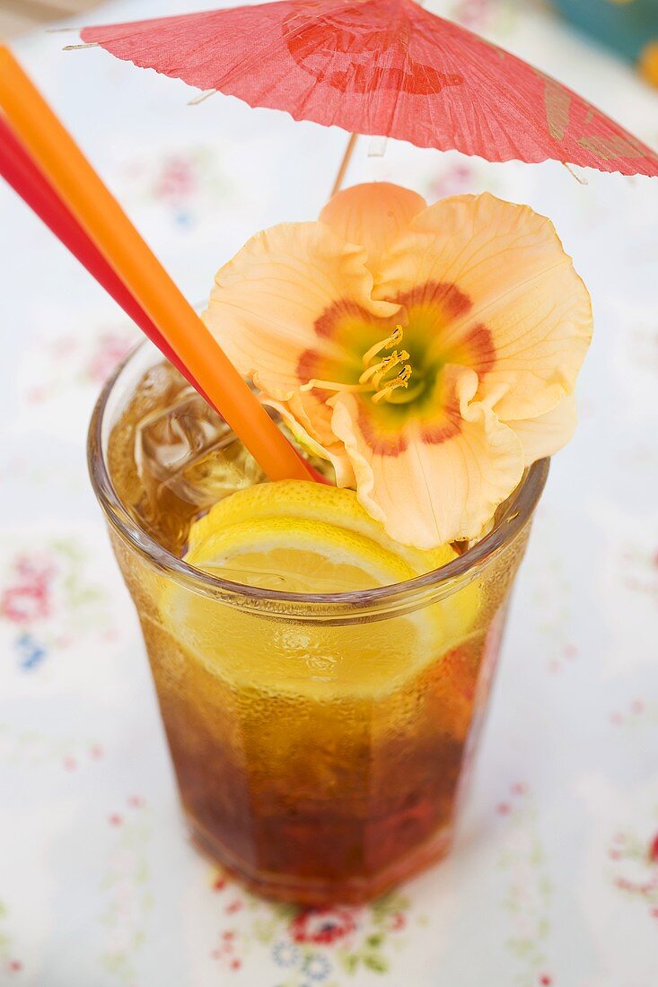 Cuba Libre mit Schirmchen und Amaryllis-Blüte