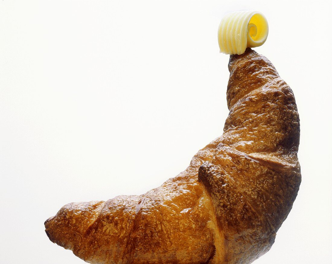 Ein Croissant mit Butterröllchen (weißer Fond)
