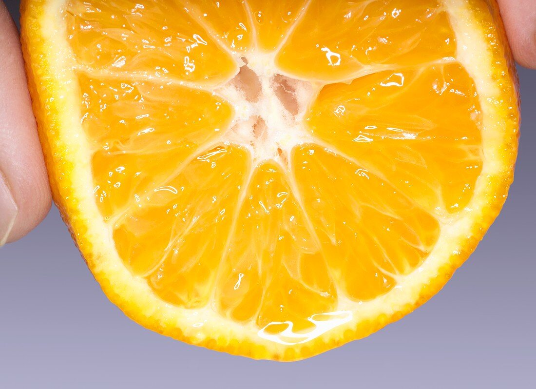 Squeezing half a mandarin orange
