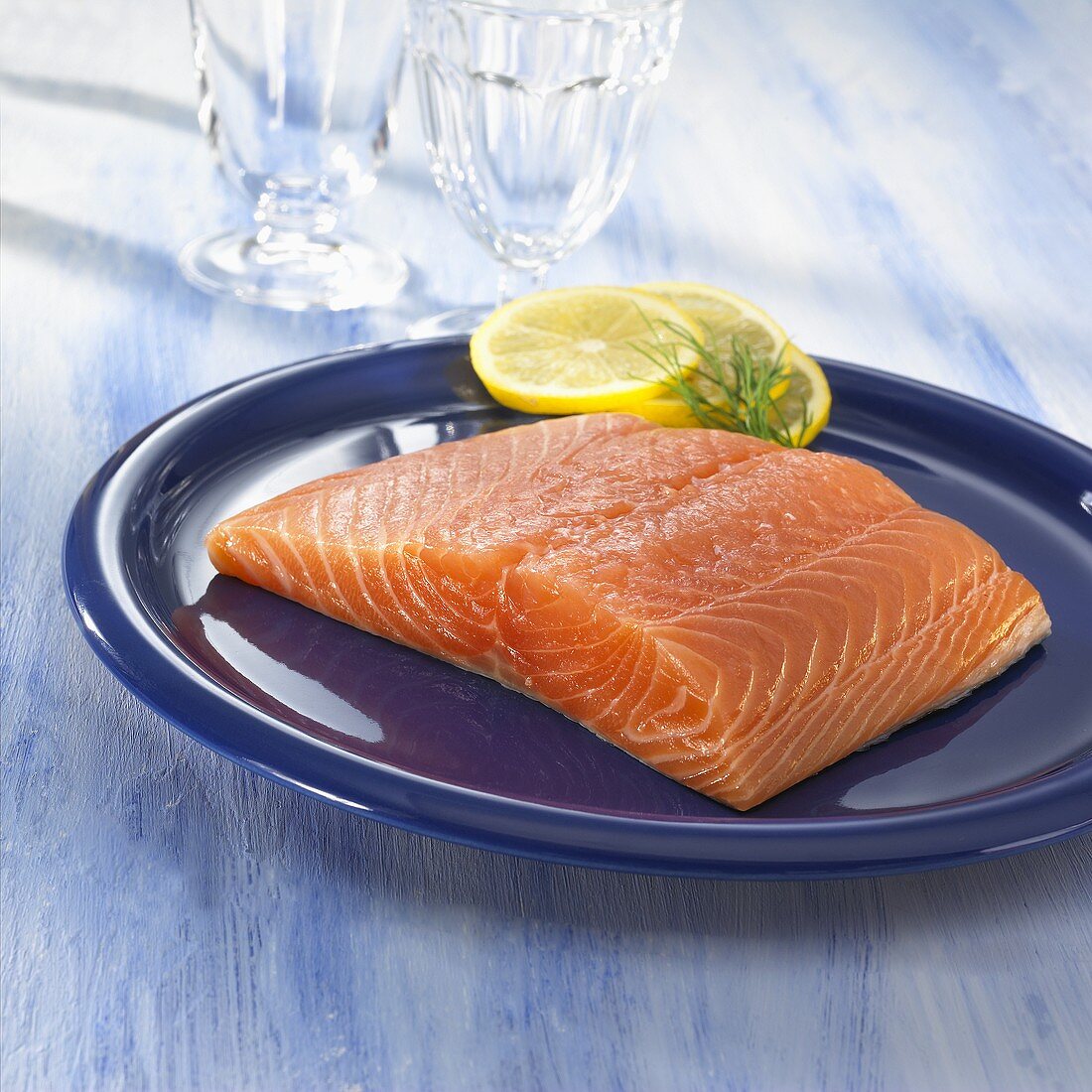 A salmon fillet with slices of lemon on a plate