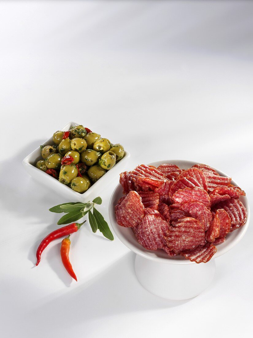 Slices of salami, green olives and chillies