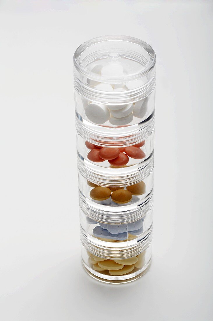 Various tablets in stacking pill boxes