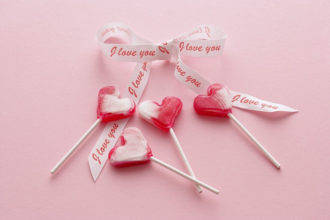 Four heart-shaped lollipops with bow