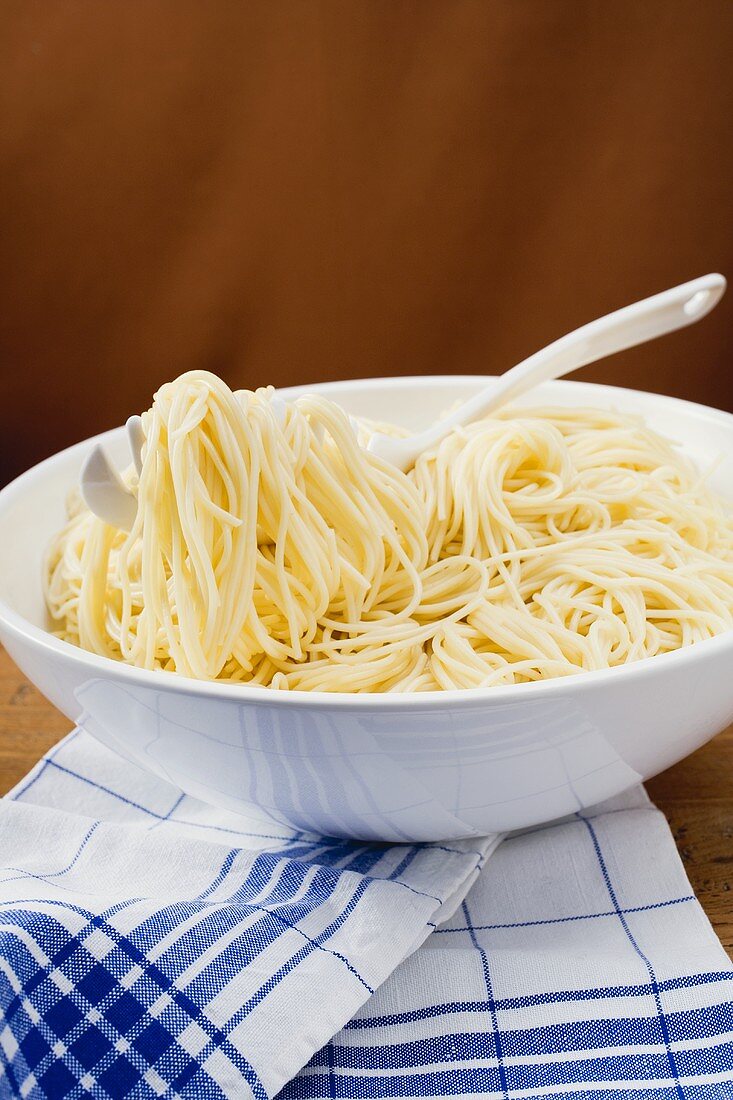 Cooked spaghetti in a dish with spaghetti server