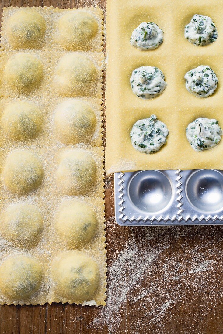 Home-made soft cheese and herb ravioli in ravioli tray