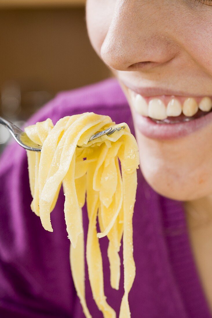 Woman eating ribbon pasta