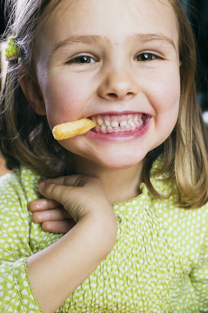 Kleines Mädchen isst ein Pommes Frites