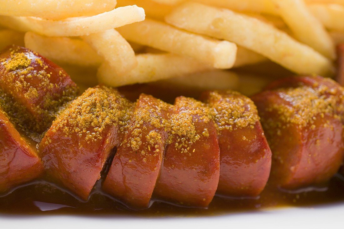 Aufgeschnittene Bratwurst mit Ketchup & Pommes Frites