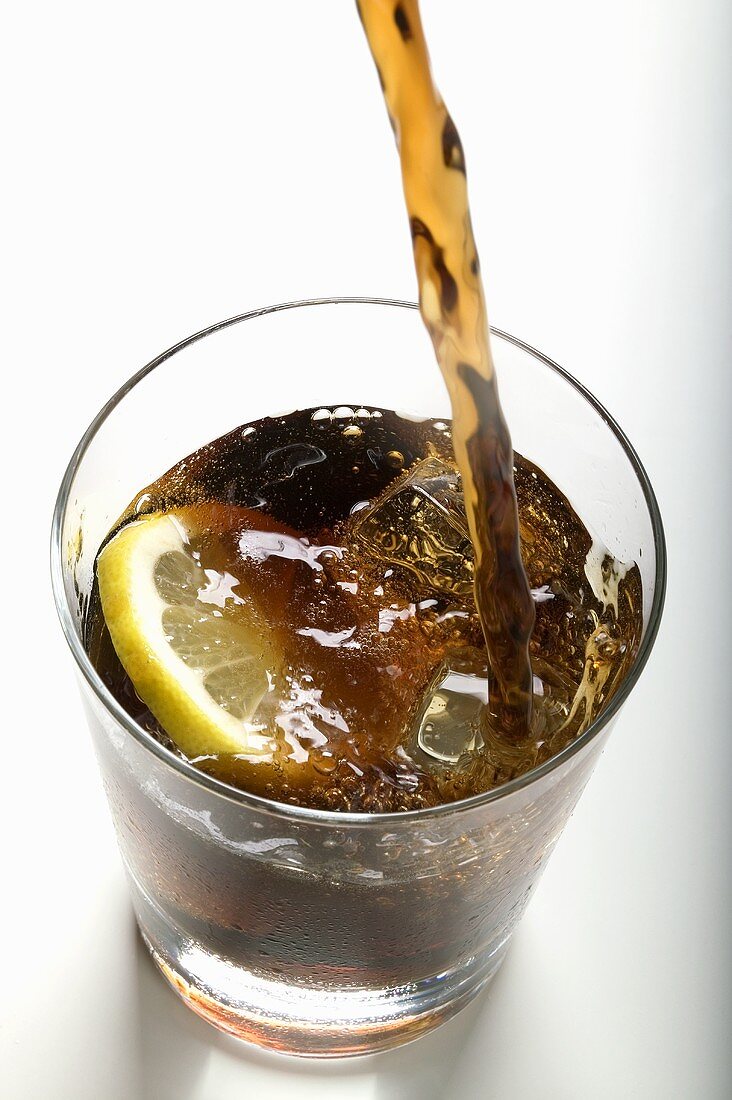 Cola in ein Glas gießen