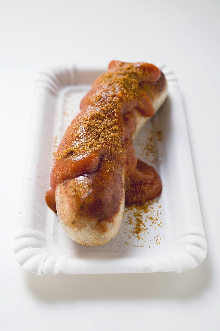 A sausage with ketchup and curry powder