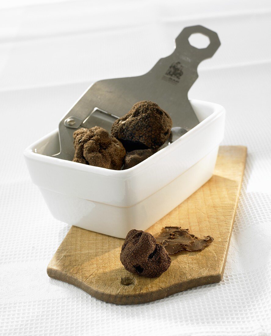 Truffles and truffle slicer in a small dish