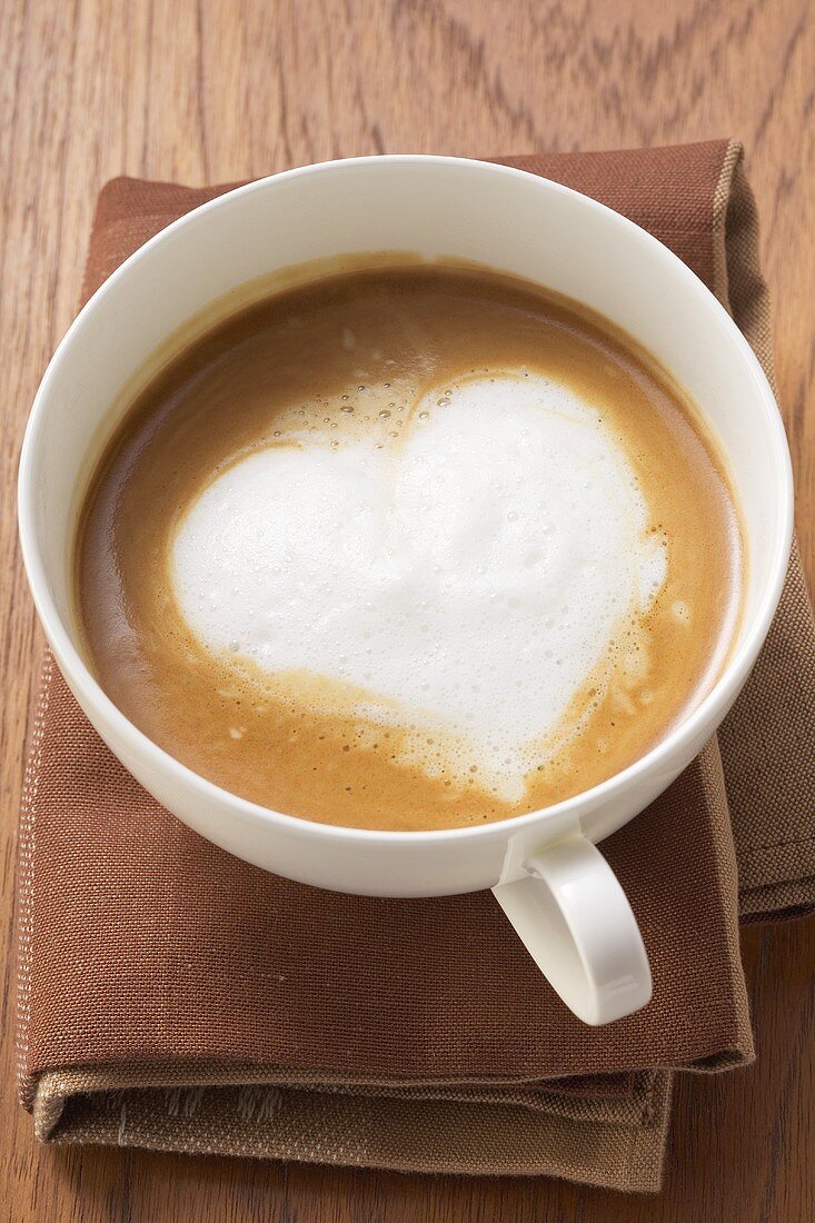 A cup of cappuccino with heart-shaped milk froth