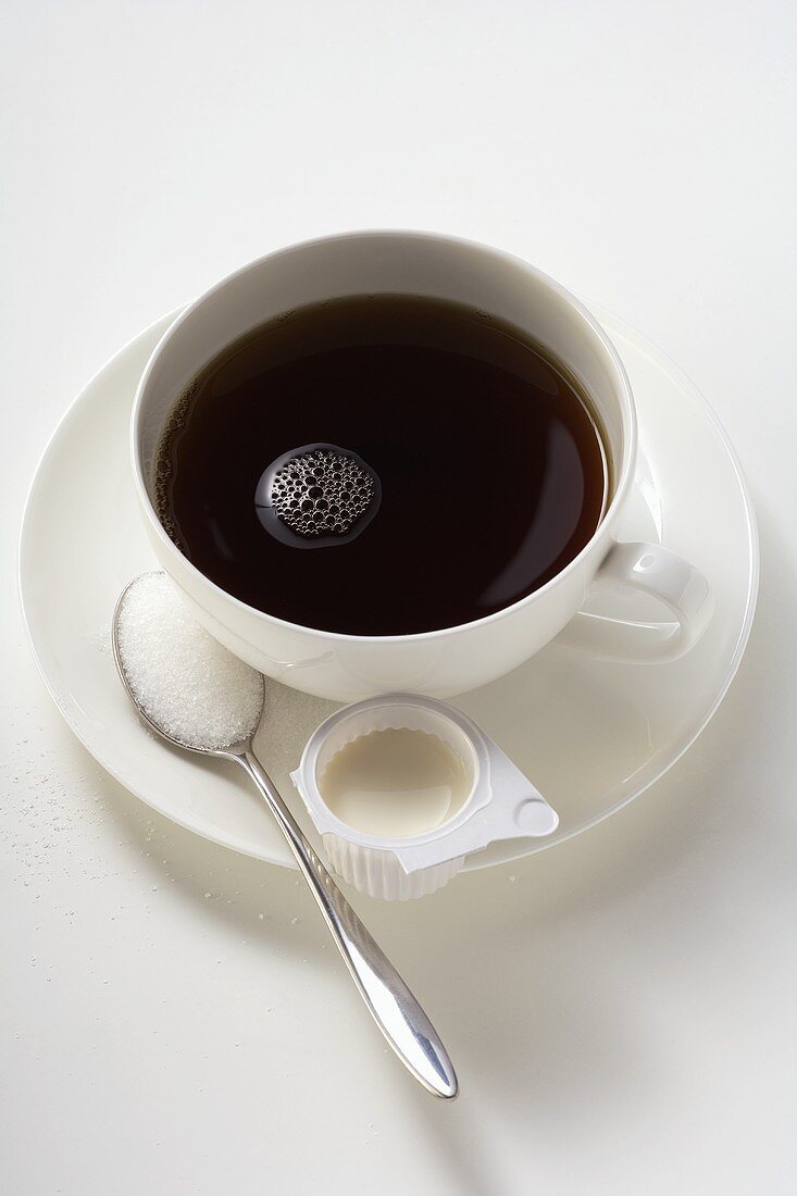 Eine Tasse Kaffee mit Milch und Zucker