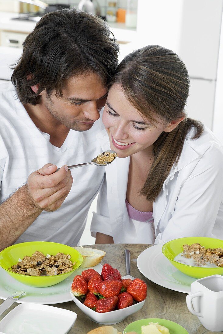 Mann füttert Frau mit Müsli