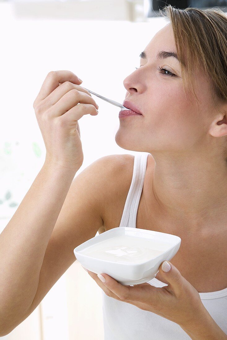 Young woman eating yoghurt