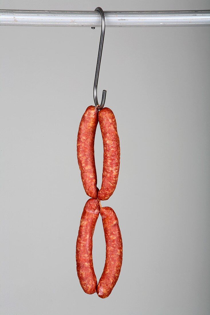 Four Mettwurst (cured, smoked pork sausages) on a hook