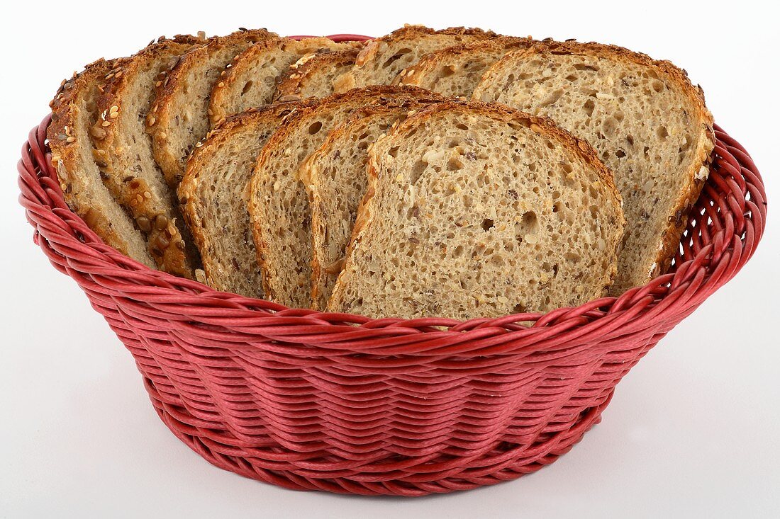 Mixed-grain bread, sliced, in red bread basket
