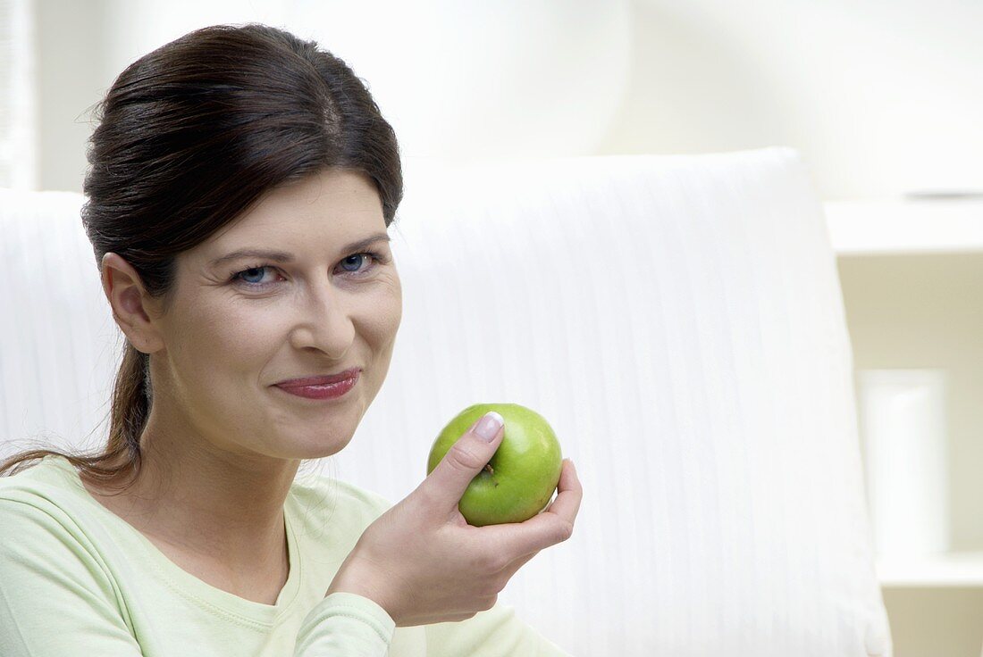 Frau hält einen Apfel in der Hand
