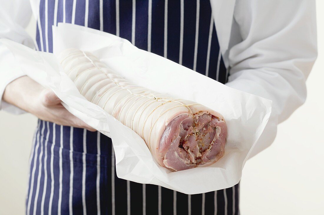 Rolled saddle of suckling pig on greaseproof paper