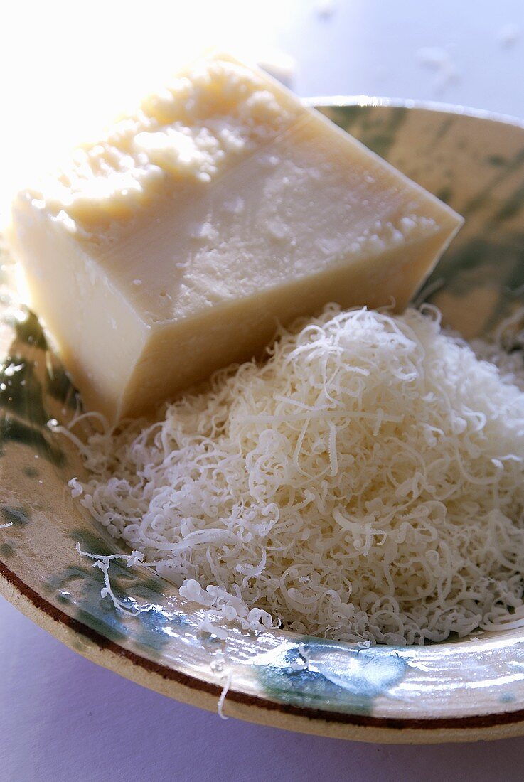 Parmesan, a piece and grated in a deep plate