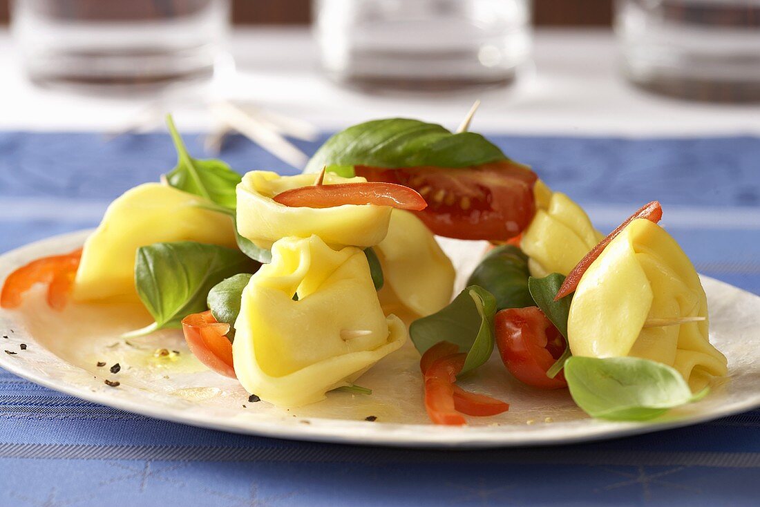 Tortellini on cocktail sticks with tomatoes and basil