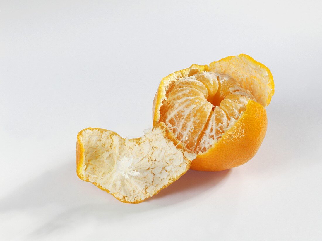 A clementine, partly peeled
