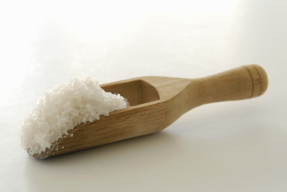 Coarse sea salt in a wooden scoop