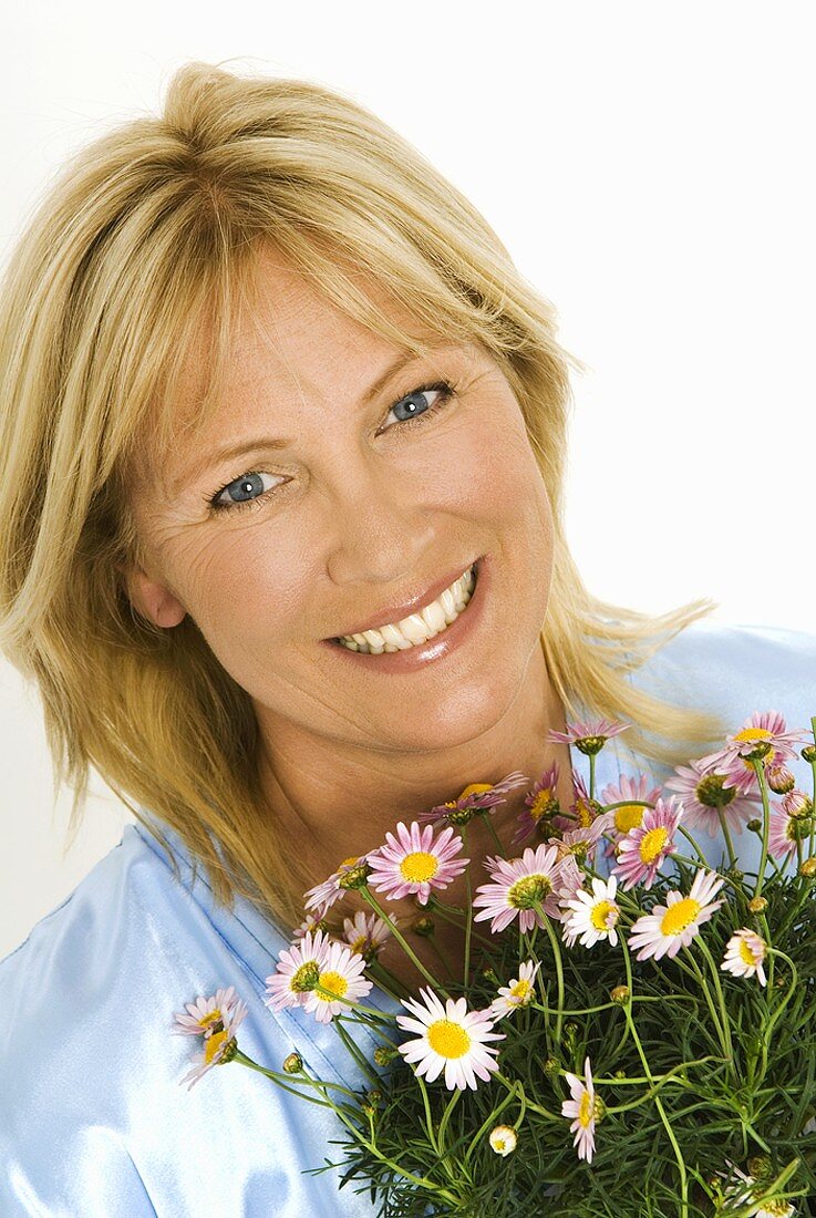 Woman holding bouquet of marguerites in her hands