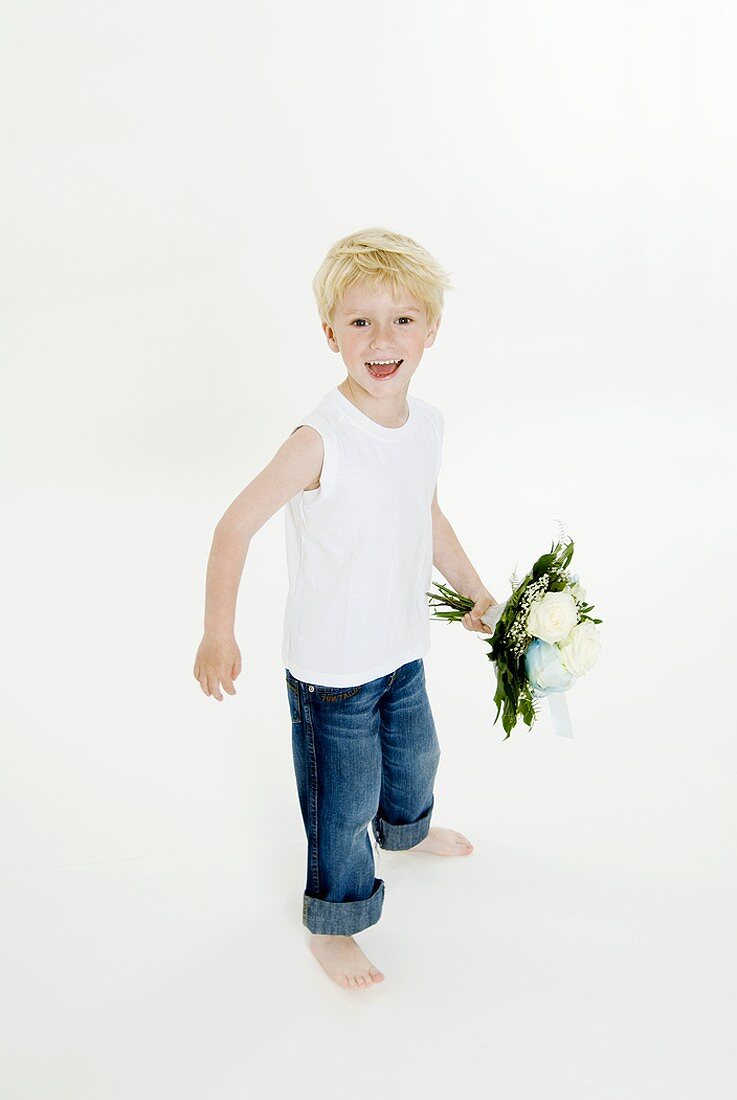 Cheerful boy with bouquet of white roses