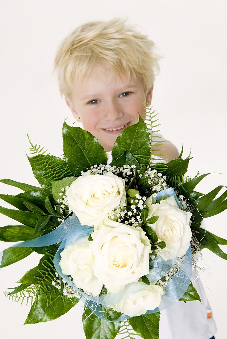 Blond boy with bouquet of white roses