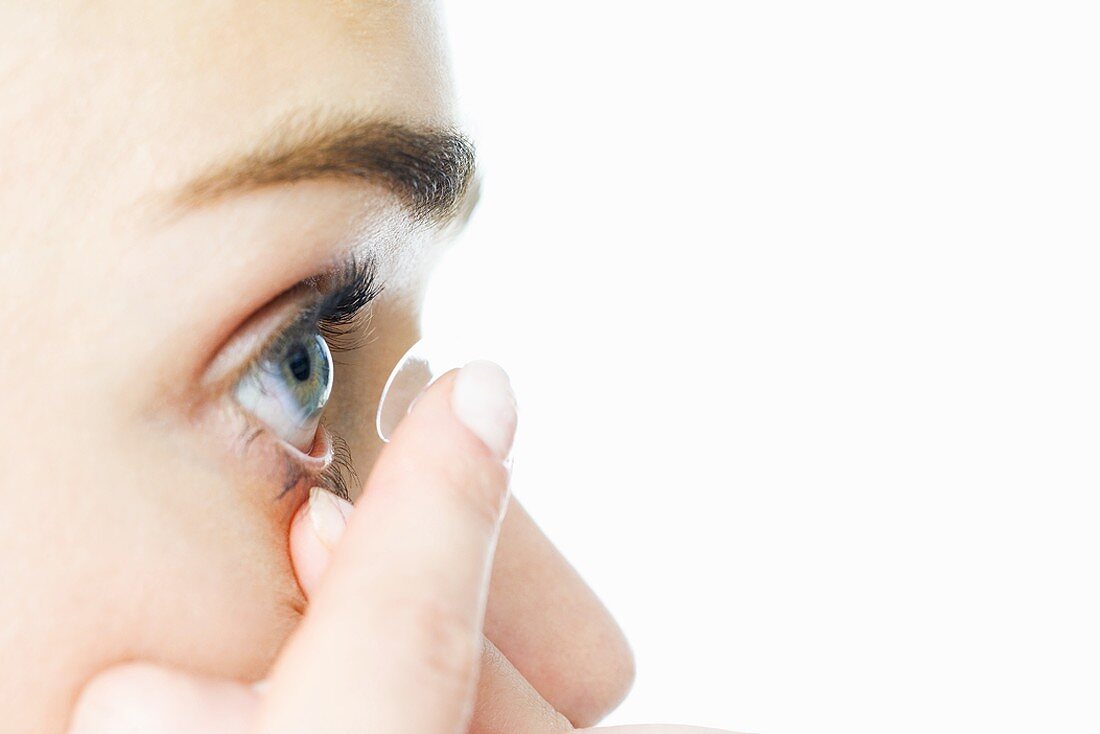 Frau beim Einsetzen von Kontaktlinsen