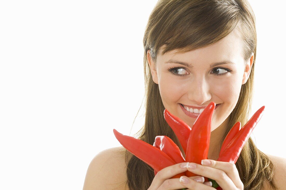 Junge Frau mit roten Peperoni