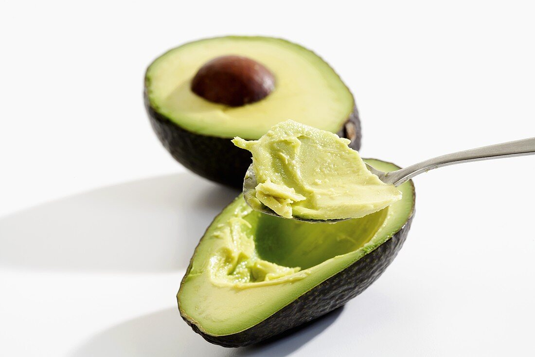 Hollowing out an avocado with a spoon