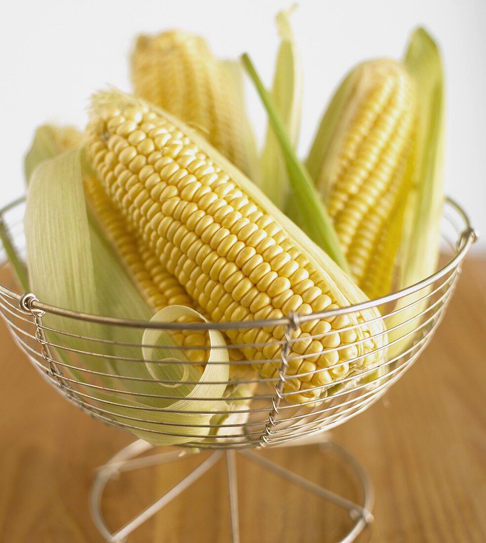 Several cobs of corn in a wire basket