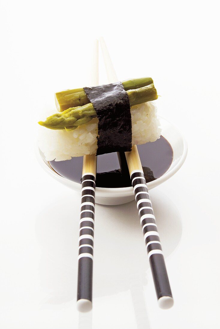 Nigiri-Sushi mit grünem Spargel, Sojasauce und Essstäbchen