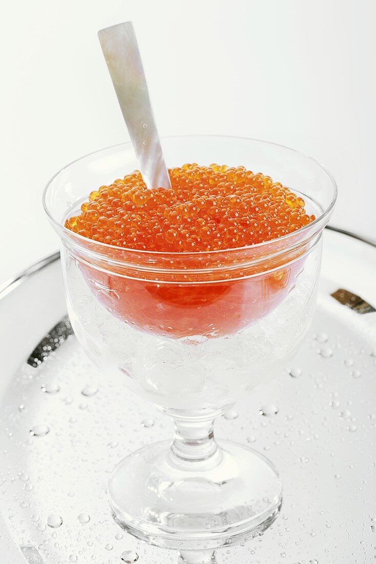 Trout caviar with mother-of-pearl spoon in glass